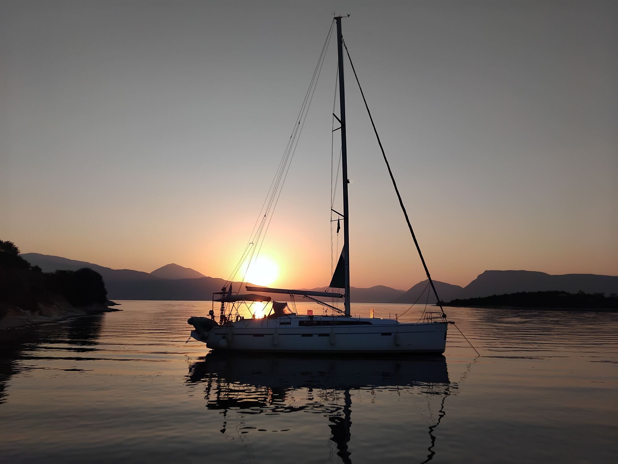 Segelyacht vor Anker in einer Bucht bei Sonnenuntergang